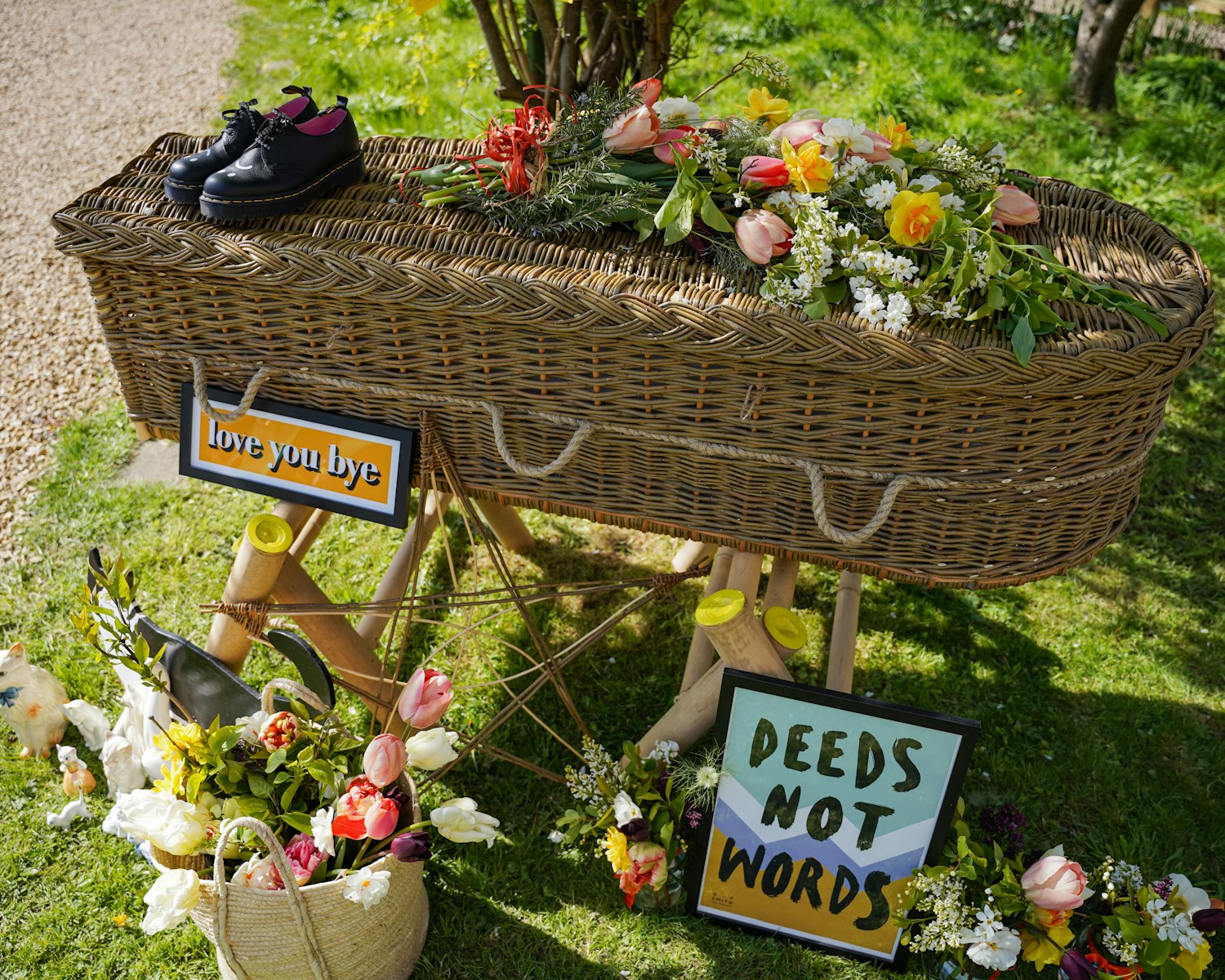 a display of flowers and shoes on display in a garden