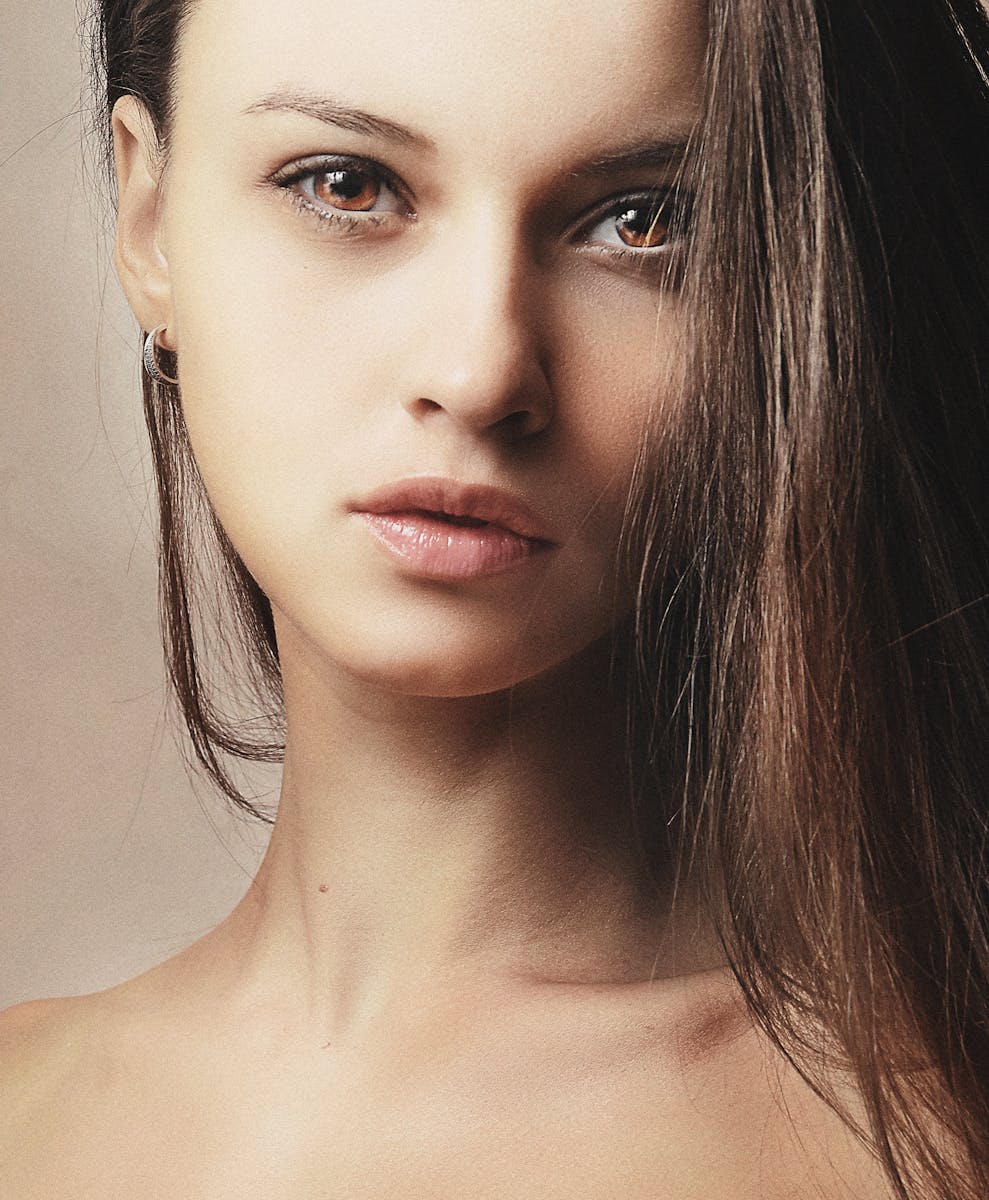 Close-up portrait of a young woman with brunette hair, showcasing natural beauty and elegance.